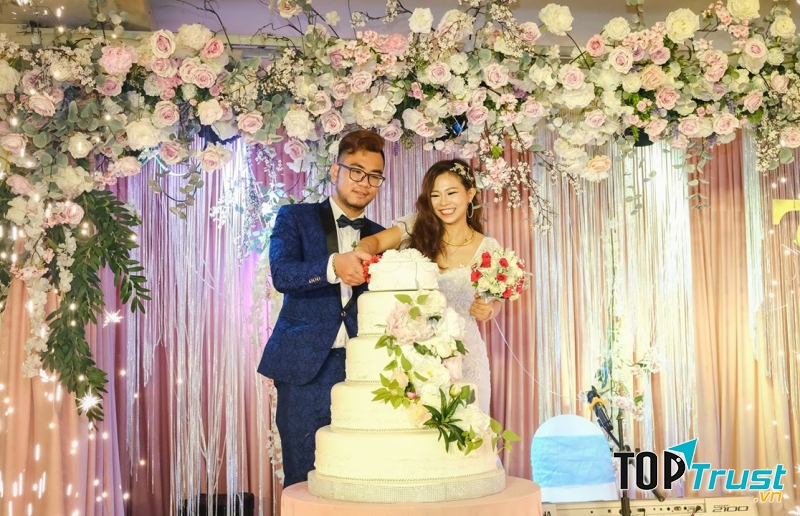 Hình ảnh cô dâu chú rể cùng nhau cắt bánh kem trong lễ cưới mình tại nhà hàng