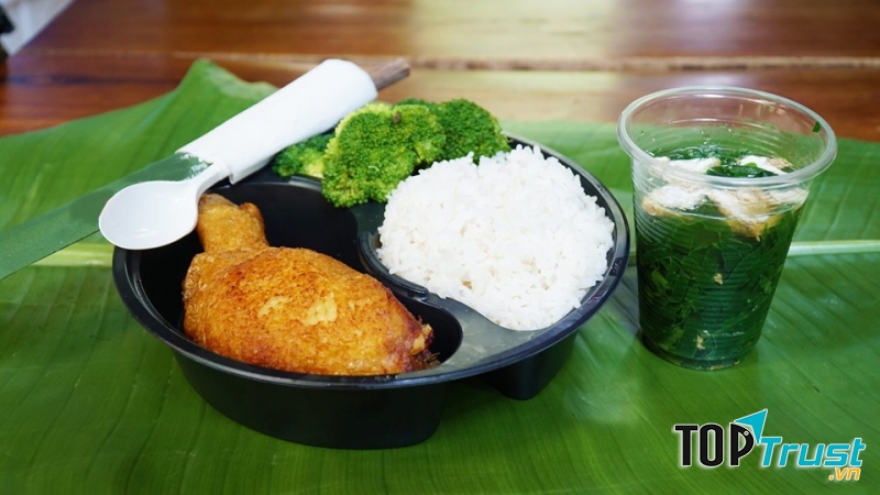 Gà chiên giòn có rưới sốt và phần rau xanh ăn kèm canh nóng.