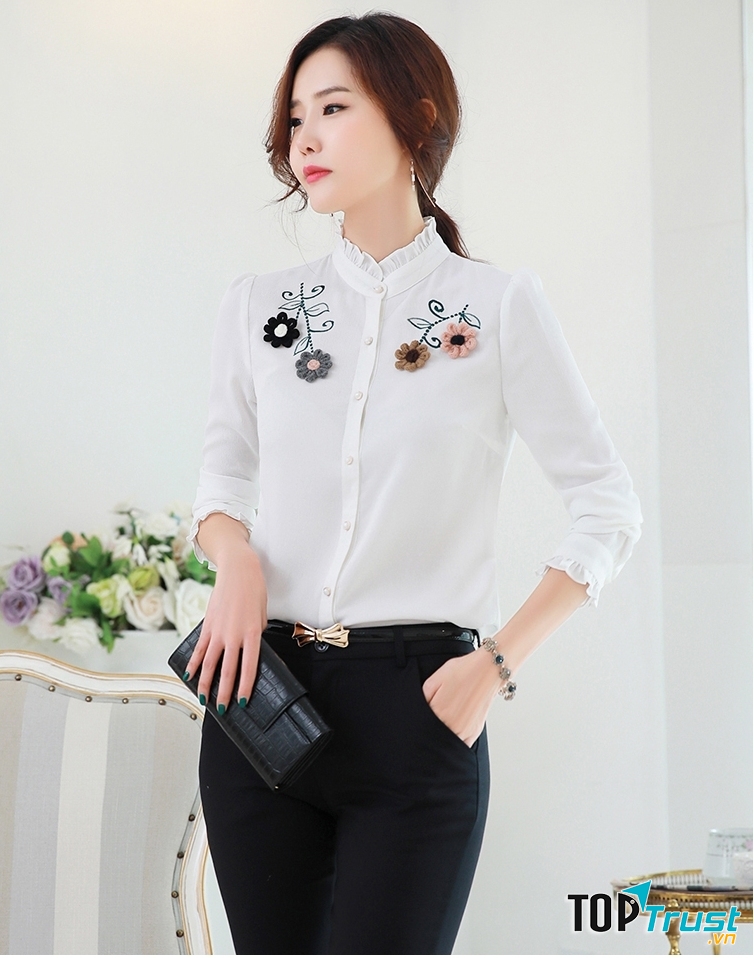 Thiết kế cổ tàu nhún bèo cùng phần hoa thêu nổi bật làm cho chiếc áo sơ mi trắng không còn đơn điệu, nhàm chán