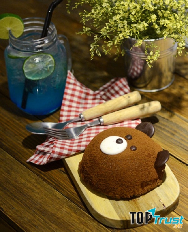 Aroi Dessert Café có không gian rộng với hai tầng lầu, nổi bật với những chùm đèn hoa lệ, ánh sáng vàng ấm áp.