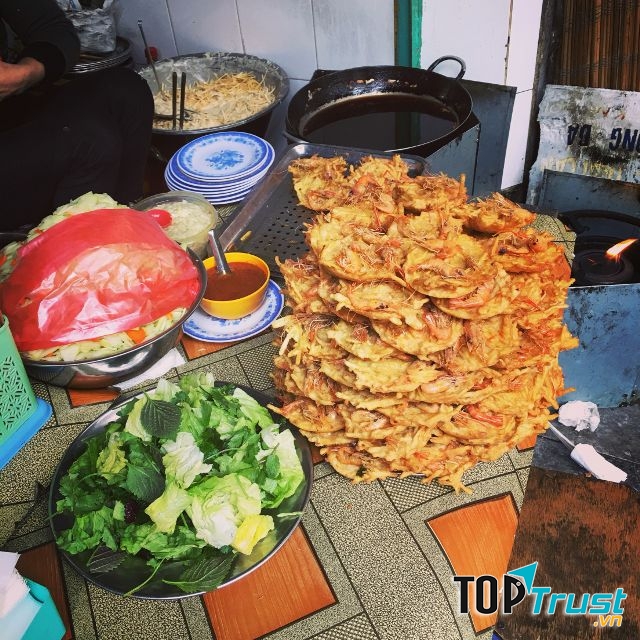 Cuộn chiếc bánh tôm chín vàng, con tôm đỏ au cong cong cùng với rau sống, hành mùi, chấm đẫm vị nước chấm chua ngọt có su hào giòn sần sật
