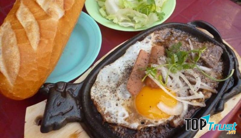 Xé một miếng bánh mì đặc ruột chấm cùng với nước sốt đậm đặc
