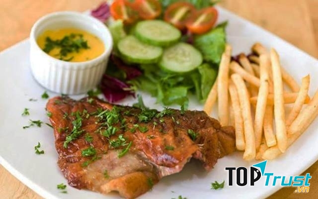 Một đĩa bò beefsteak gồm khoai tây, nước chấm và rau củ quả