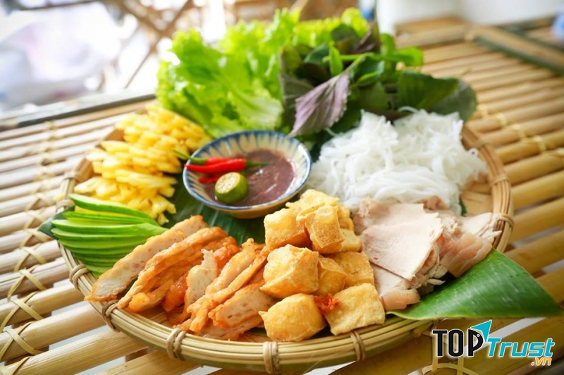 Mẹt bún với vài miếng bún hình vuông, vài lát thịt luộc, đậu hũ chiên vàng ruộm còn nóng hổi, miếng chả cốm giòn tan