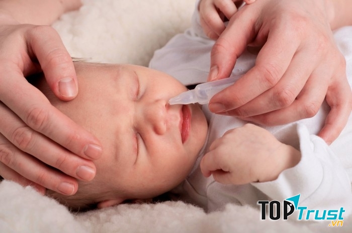 Sử dụng dung dịch nước muối sinh lí để vệ sinh mắt, mũi cho bé.