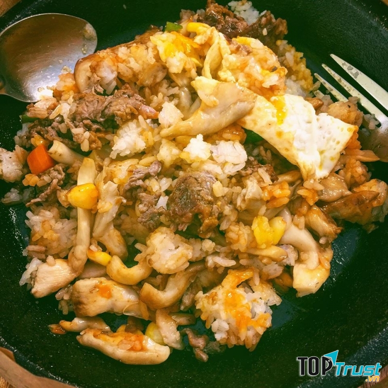 Đồ ăn để trên chảo nóng, rưới nước sốt, trộn xèo xèo, vừa ăn vừa xuýt xoa