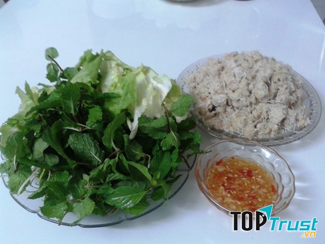 Thưởng thức chuối quết dừa không thể thiếu các loại rau ghém, rau thơm, bánh tráng và chén nước chấm chua ngọt