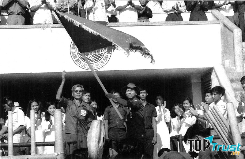Đồng chí Võ Văn Kiệt, Chủ tịch Ủy ban nhân dân Cách mạng Thành phố Sài Gòn – Gia Định trao cờ truyền thống của Đoàn Thanh niên Cộng sản Hồ Chí Minh cho đồng chí Phạm Chánh Trực, Bí thư Thành Đoàn Thành phố trong ngày ra quân của Lực lượng Thanh niên Xung phong tại Sân vận động Thống Nhất, ngày 28 tháng 3 năm 1976 - Ảnh: Tư liệu