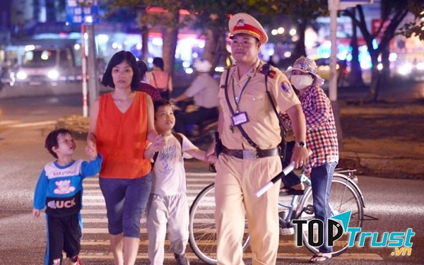 Công an giao thông dẫn người dân qua đường lúc đang làm nhiệm vụ