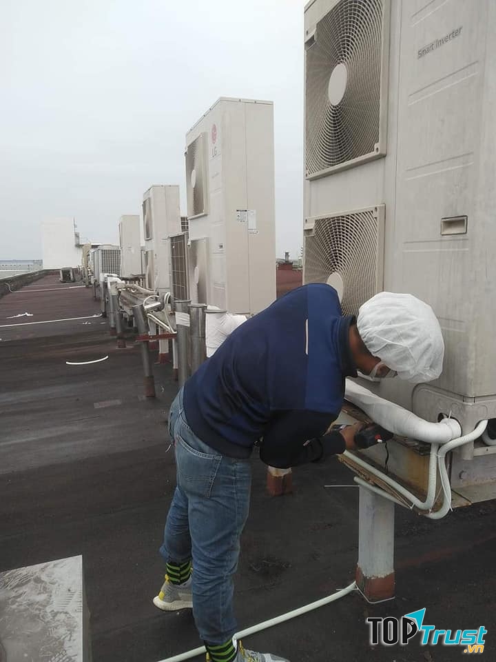 Hai nhân viên đang sửa chữa điều hòa