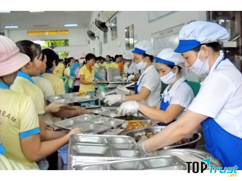 Công nhân xếp hàng lấy suất ăn của mình