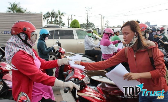 Cộng tác viên đang phát tờ rơi đến khách hàng