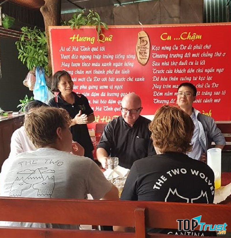 Bà chủ Đặng Thanh đang tiếp đoàn khách nước ngoài ghé thăm quán, thưởng thức cu đơ