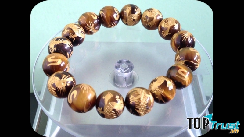 Vòng tay đá mắt hổ chạm trổ rồng .