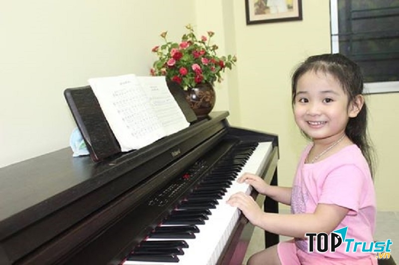 Bé học chơi đàn piano.
