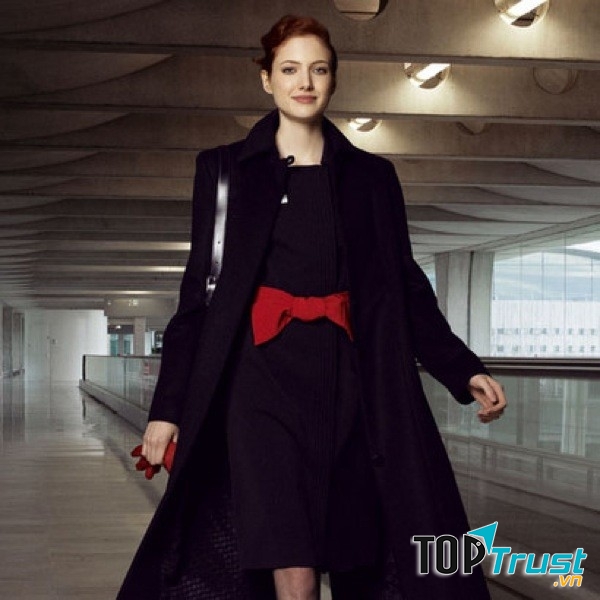 Váy liền dài, áo choàng đen và nơ đỏ tạo nên bộ trang phục đầy quyến rũ mà vẫn rất tinh tế