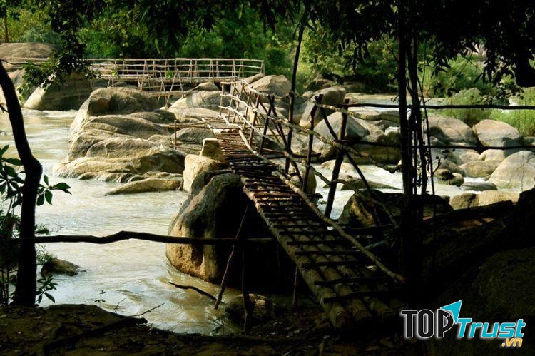 Chiếc cầu mộc mạc đơn sơ bắt ngang qua con suối nhỏ.