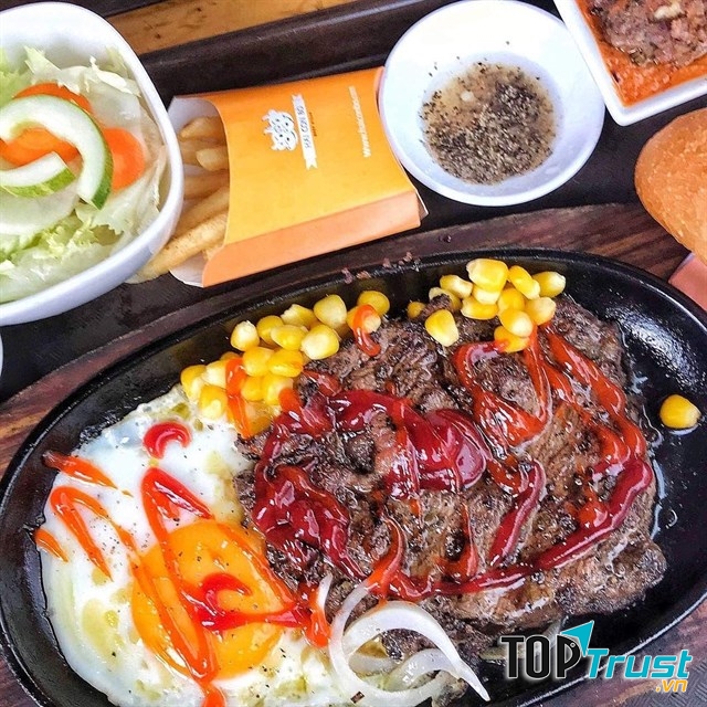 bò né, đĩa salad, khoai tây chiên và bánh mì