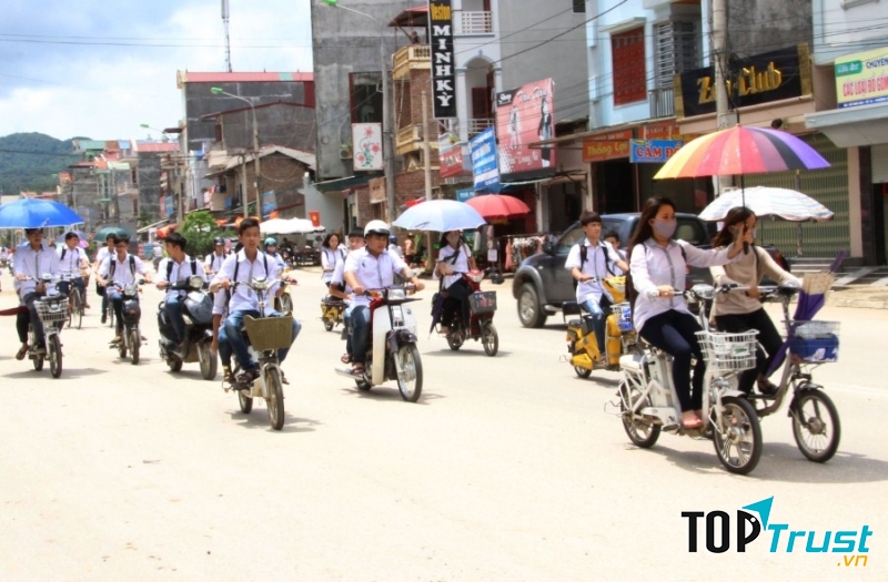 Học sinh dàn hàng ngang và sử dụng ô khi đi xe
