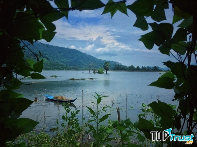 Một người dân đang đánh bắt cá bên cạnh chiếc thuyền nhỏ trong hồ Ô Tà Sóc