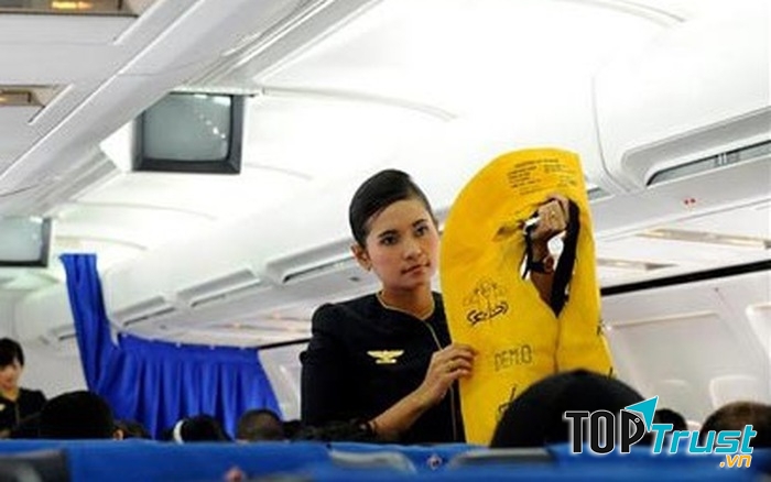 Tiếp viên hàng không đang hướng dẫn an toàn bay cho hành khách.