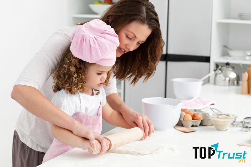 Hãy khuyến khích bé phụ bạn nhặt rau, rửa rau, trộn thức ăn, dọn bàn ăn cho cả nhà.