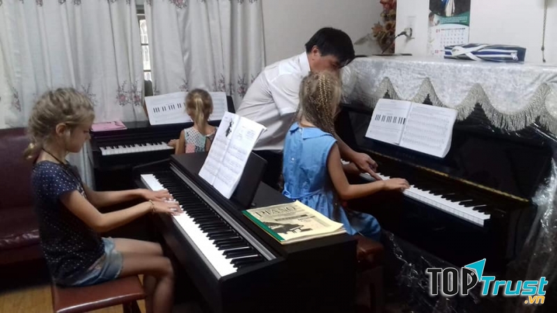 Thầy dạy đàn cho các bé