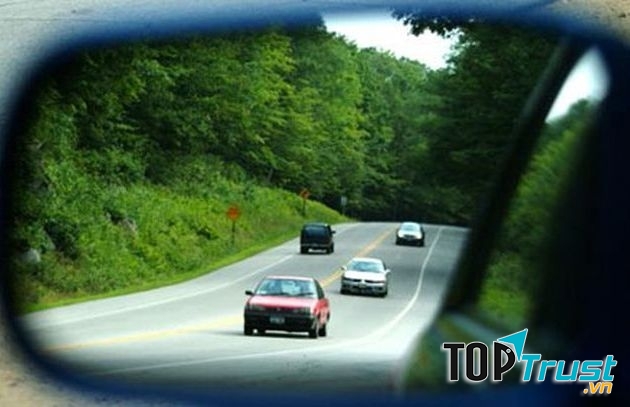 Nhìn gương chiếu hậu.