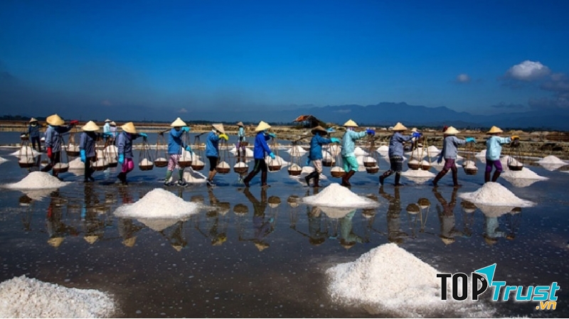 Từng hàng những người dân đang gánh muối về kho