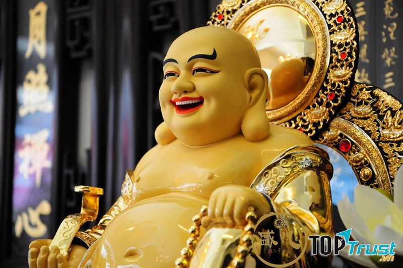 Phật Di Lặc: mập mạp, bụng to, mặt tươi cười hoan hỷ, tay trái cầm xâu chuỗi, tay phải cầm gậy ngọc Như Ý-biểu tượng của cát tường, thịnh vượng