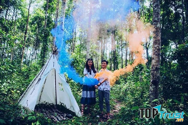 Hai bạn trẻ đang chụp ảnh đôi  phong cách cắm trại với pháo màu