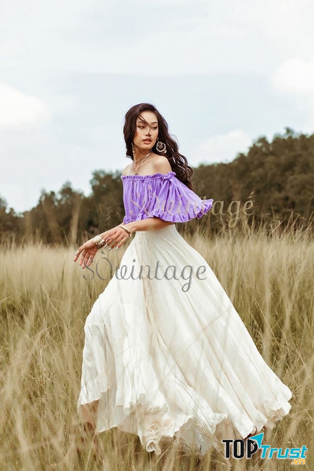 Chiếc đầm maxi trắng với form dáng dài kết hợp áo trễ khoe bờ vai trần tạo nên vẻ thướt tha, quyến rủ mê lòng người