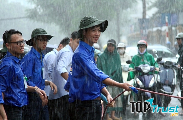 Không ngại mưa gió giúp đỡ người xung quanh qua vùng nước ngập.