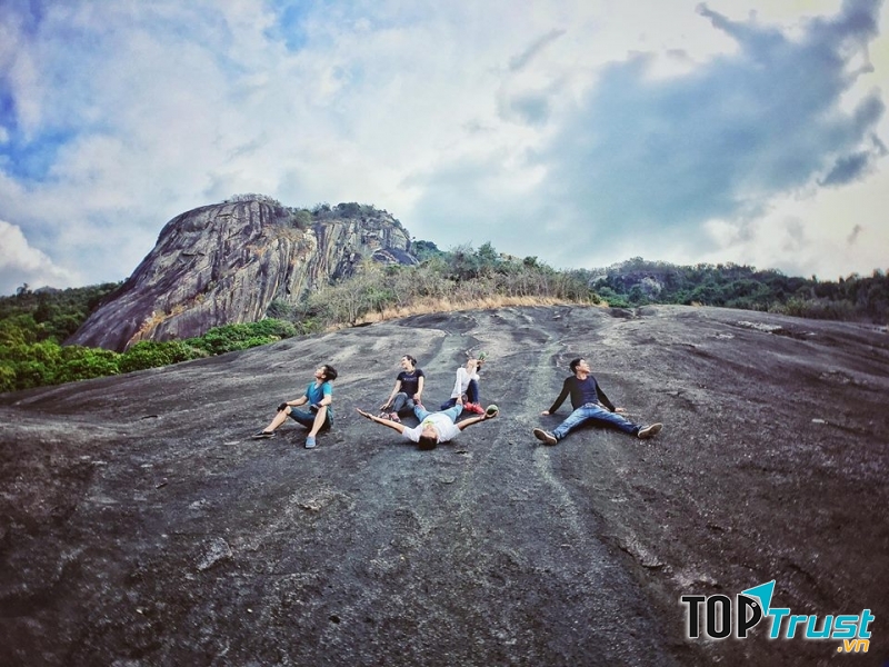 Các bạn trẻ thích thú tạo dáng trên tảng đá, phía sau là tảng đá Đầu Voi