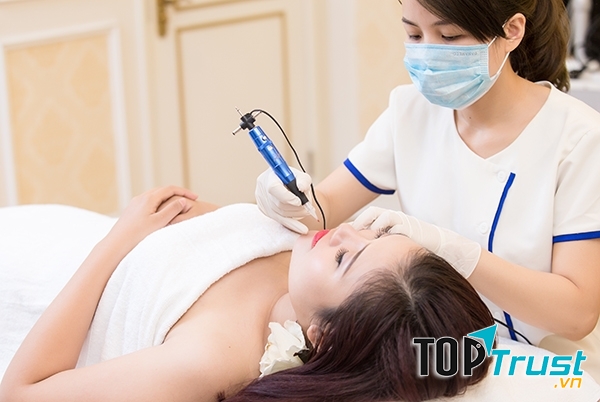 Chuyên viên thực hiện phun xăm môi cho khách hàng