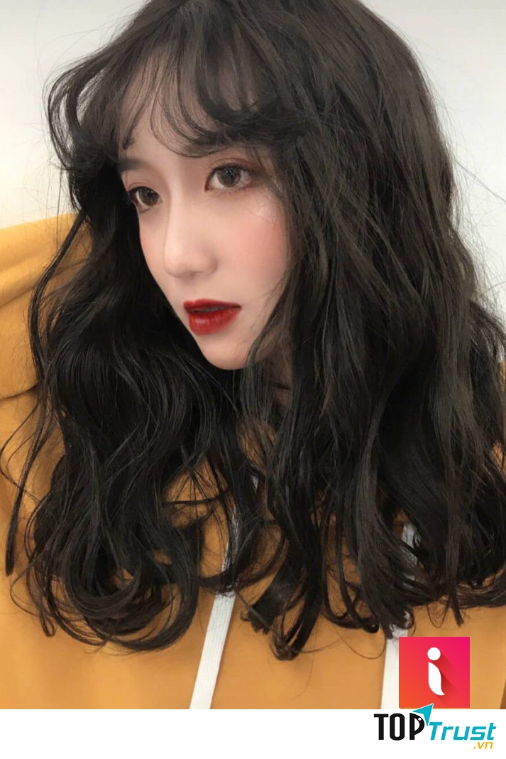 Tóc lửng uốn xoăn sóng to gợi lên sự bồng bềnh, gợi cảm nhưng cũng nổi bật lên cá tính mạnh mẽ.