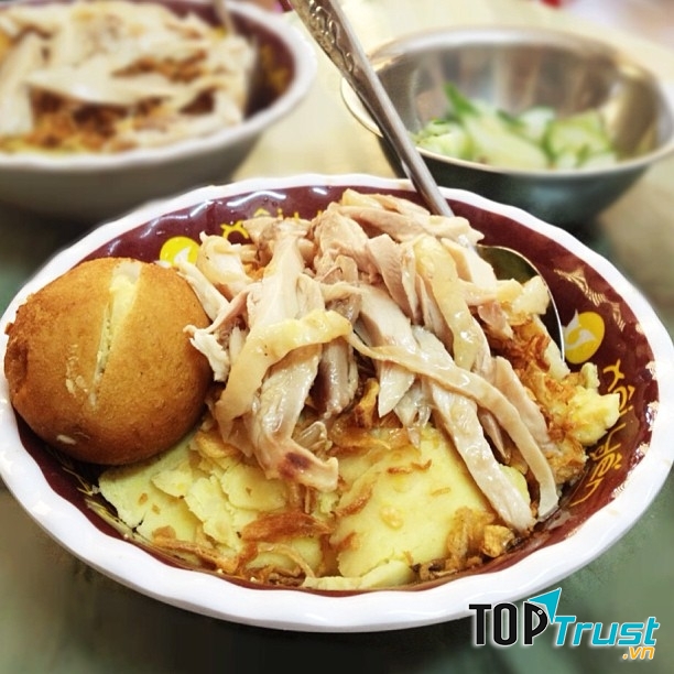 Hạt xôi tròn mẩy nấu mềm, tưới nước gà béo ngậy và đồ ăn kèm phủ đầy lên trên